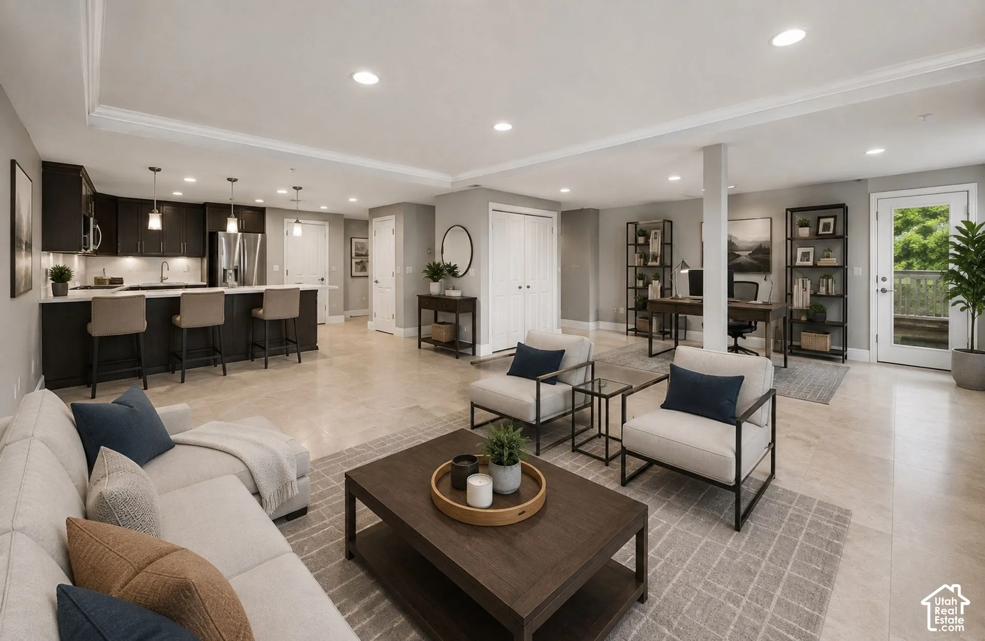 Open-concept living space with recessed lighting, crown molding, and light-toned flooring