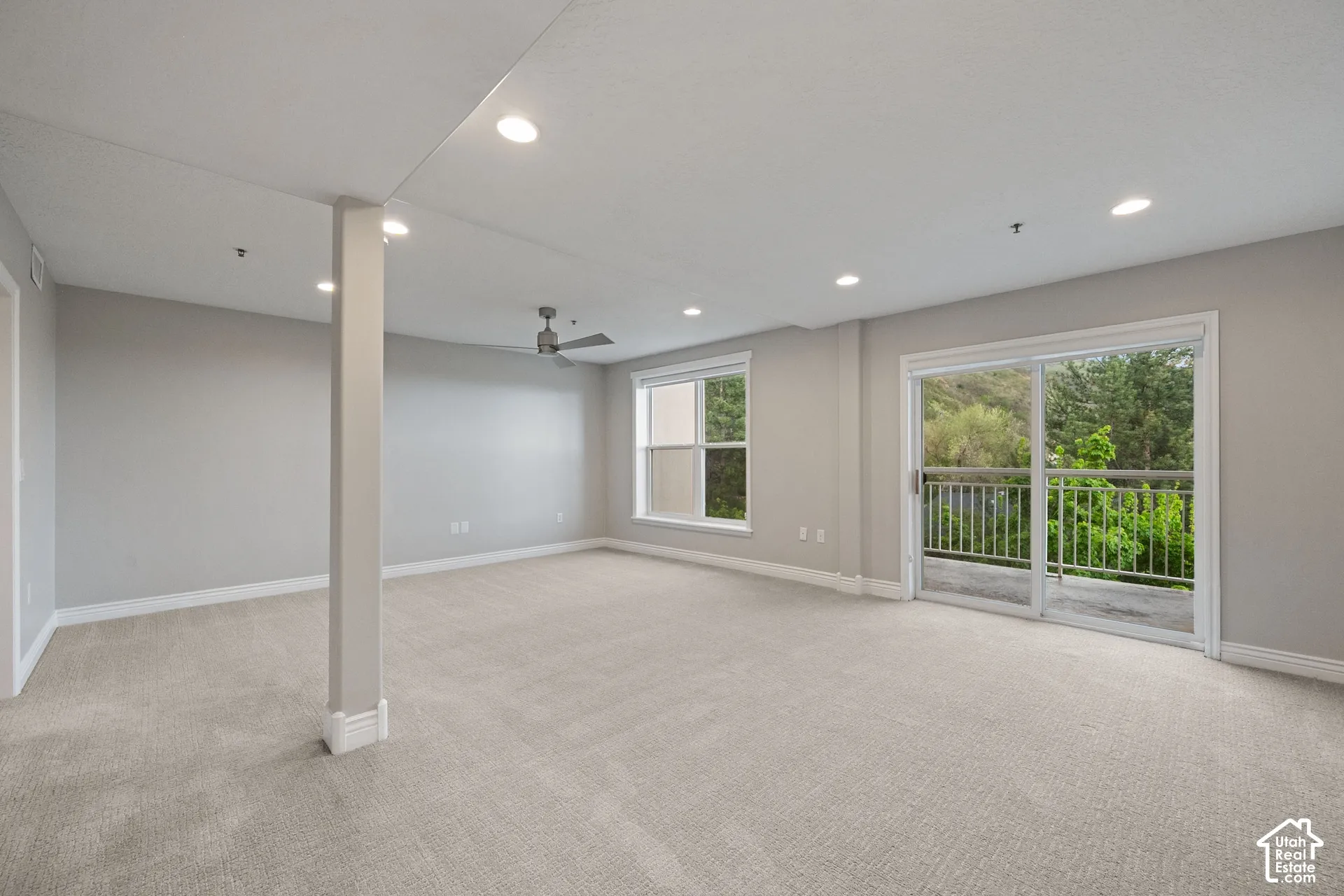 Recessed lighting, light-toned carpet, ceiling fan, sliding glass door, and white trim
