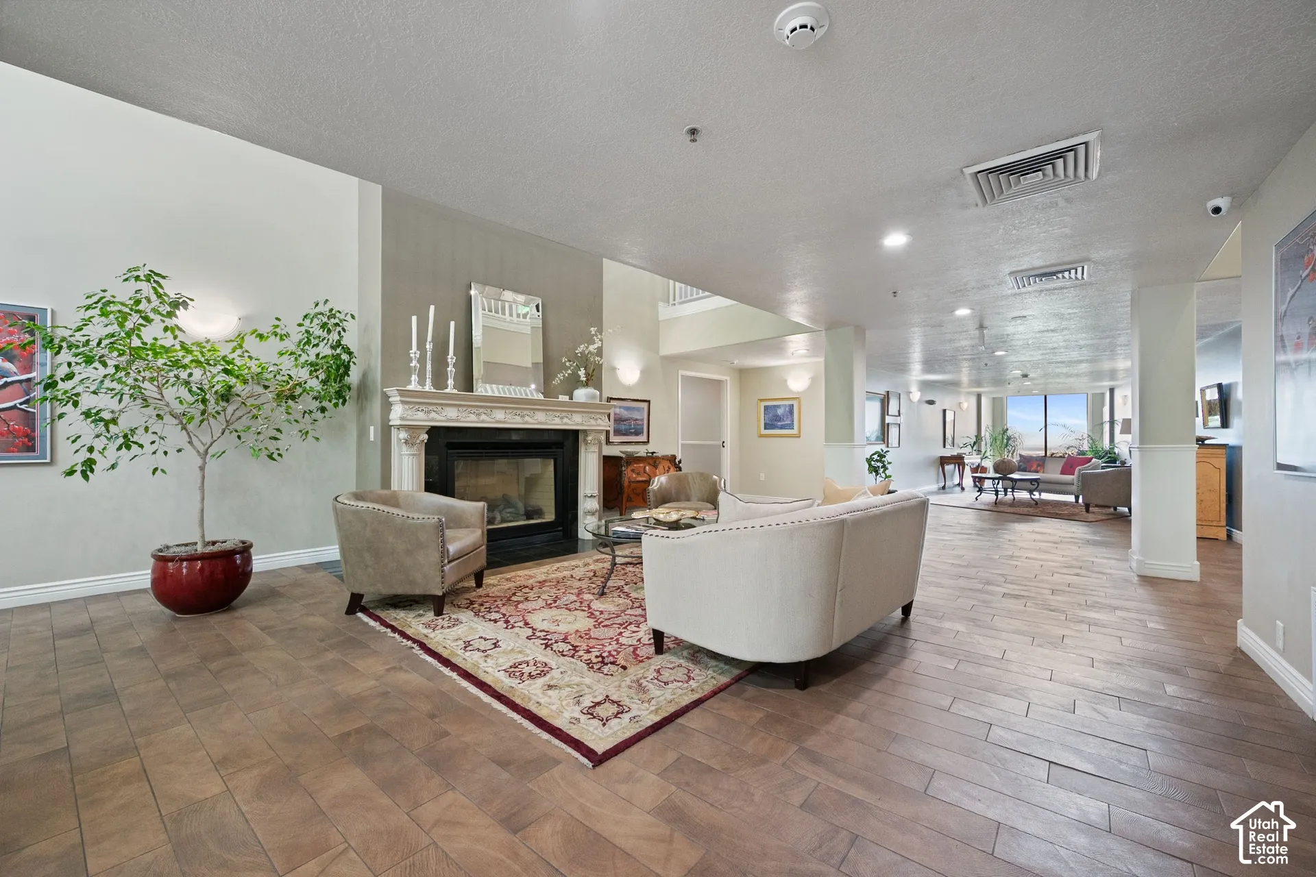 Ornate fireplace with decorative mantel, wood-finish flooring, recessed lighting, and wall sconces
