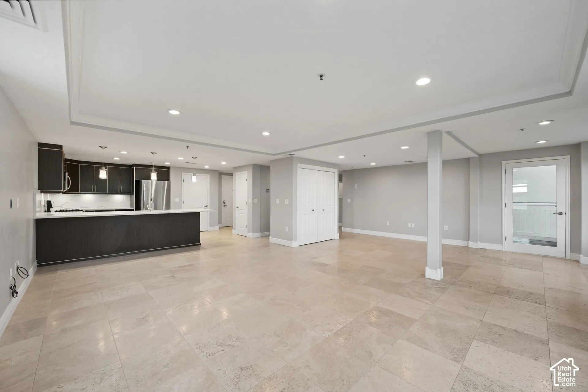 Open-concept living space with large format tile flooring and recessed lighting