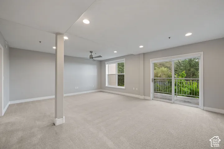 Recessed lighting, light-toned carpet, ceiling fan, sliding glass door, and white trim