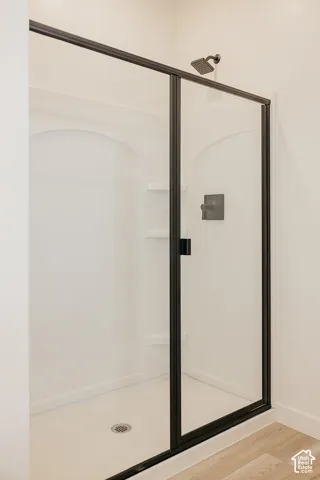 Shower enclosure with clear glass paneling, matte black framing, and a rain-style shower head