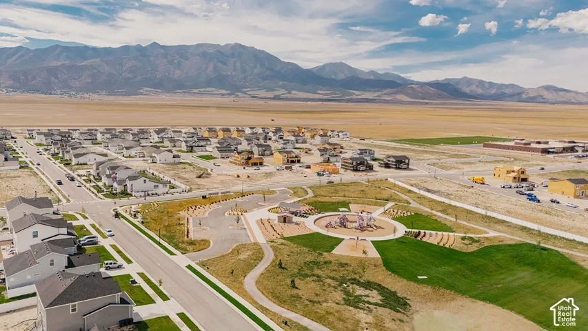 Community park with recreational equipment, manicured green space, and paved pathways
