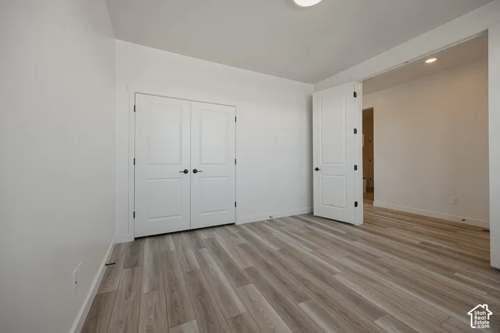 Wood-finish flooring throughout, white interior walls, and recessed ceiling lighting