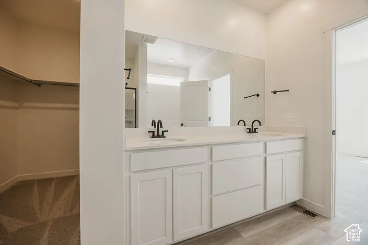 Dual-sink vanity with white cabinetry, quartz countertops, and matte black faucet fixtures