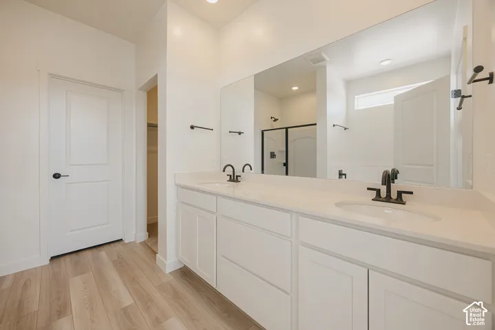 Dual vanity with undermount sinks, light-toned countertops, and matte black fixtures