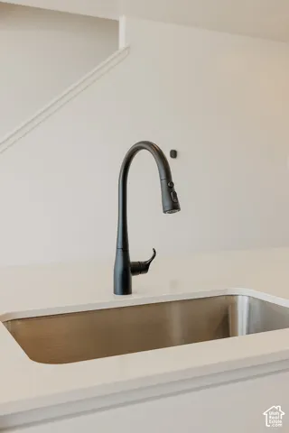 Stainless steel undermount sink with a matte black pull-down faucet, set into a light-toned countertop