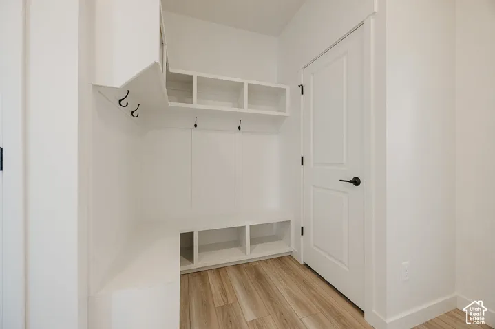 Built-in storage bench with open cubbies, upper shelving units, and integrated coat hooks