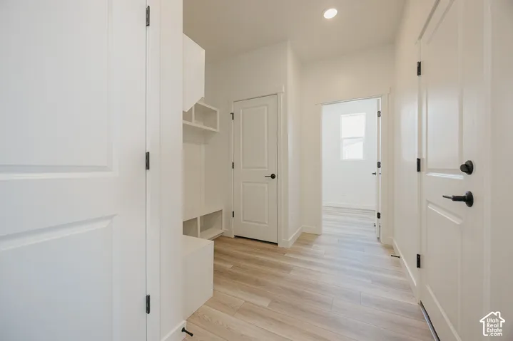 Built-in storage solutions, wood-finish flooring, recessed lighting, and white paneled doors with matte black hardware