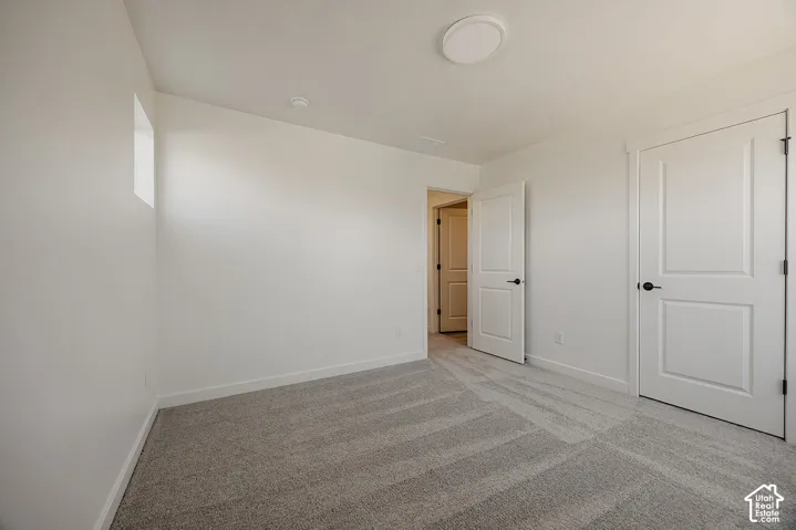 Neutral tone wall finish, plush carpet flooring, recessed ceiling lighting, three-panel interior doors, and matte black hardware