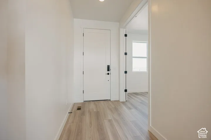 Wood-finish flooring throughout, white interior doors, and modern door hardware