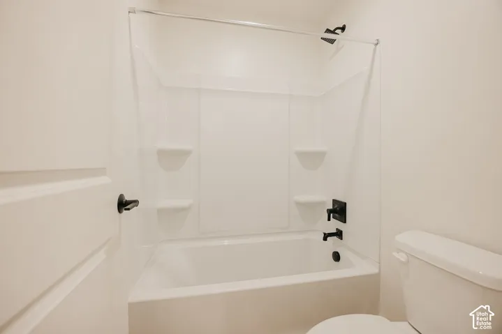 Clean, bright bathroom featuring a white subway tile surround with built-in shelving niches, a soaking tub with chrome fixtures, and a rainfall showerhead for a spa-like bathing experience