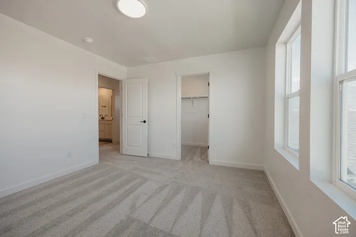 Light gray carpeting, white walls, and bright overhead lighting