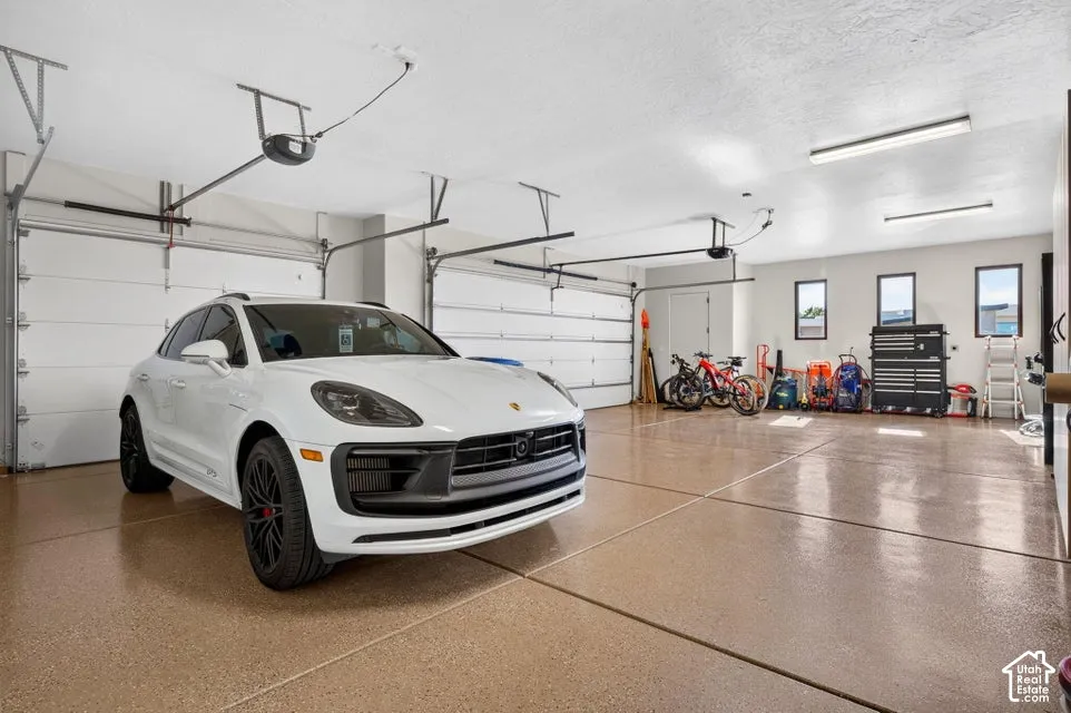 Three-car garage featuring segmented overhead doors and epoxy flooring