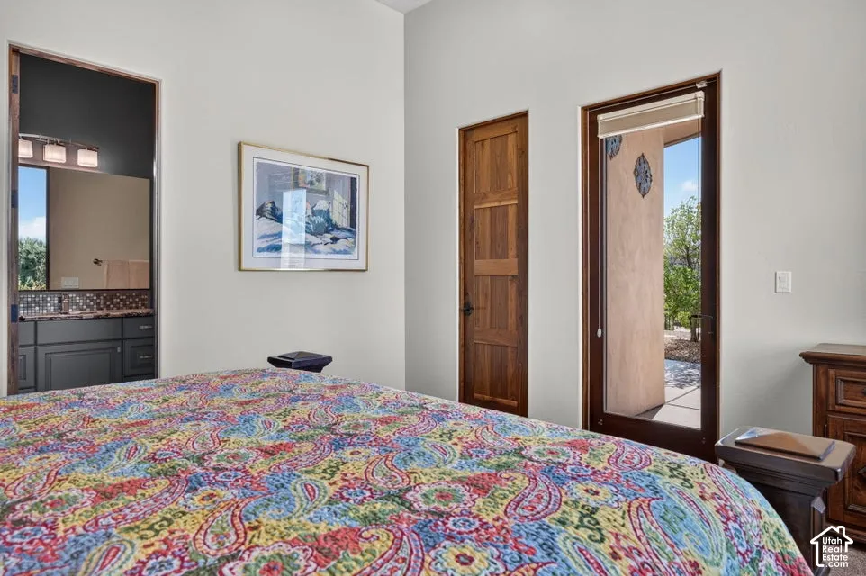Wood-finish paneled door, full-light exterior door with roller shade, and an en-suite bathroom entry with dark wood-finish vanity and mosaic tile backsplash