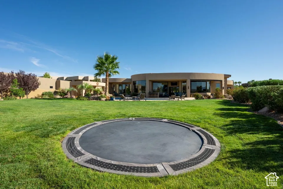 Expansive green lawn with an in-ground round feature, complemented by mature landscaping