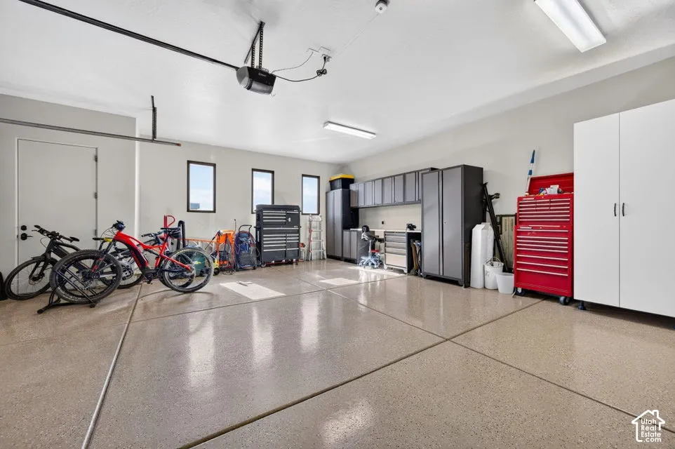Spacious garage featuring an epoxy-coated floor, multiple windows, and recessed lighting