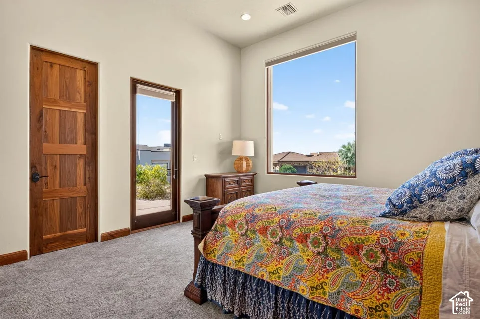 Wall-to-wall carpeting, wood-finish door, large window, recessed lighting, and patio access
