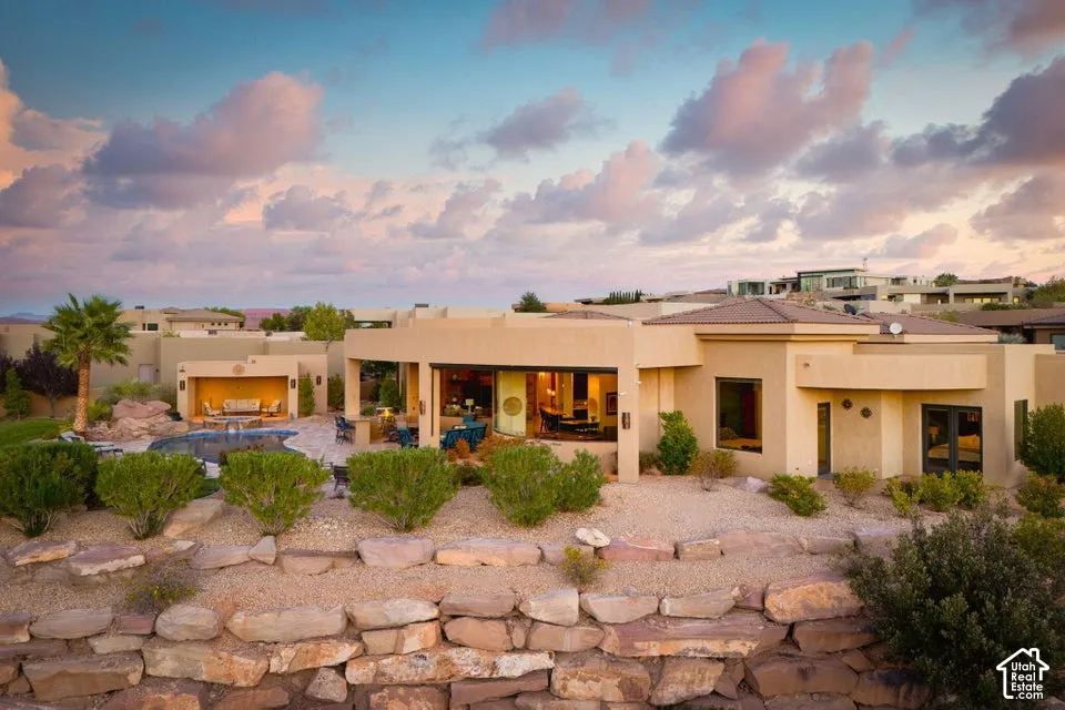 Southwestern-style exterior with a stucco finish and a multi-level stone retaining wall