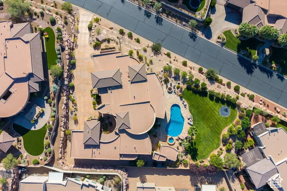 Expansive property featuring a large swimming pool, integrated hot tub, substantial manicured lawn, and extensive hardscaping