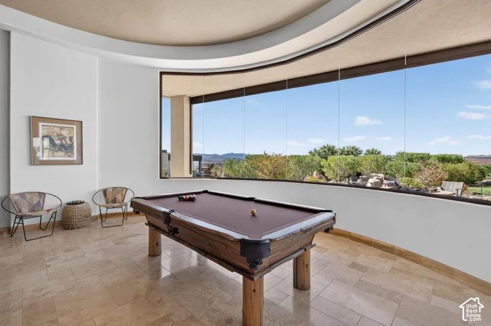 Curved floor-to-ceiling windows, extensive outdoor landscaping, and polished tile flooring