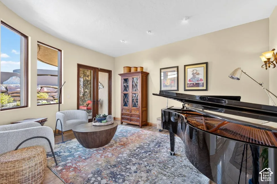 Two large windows, wood-finish flooring, recessed lighting, and a glass-paneled double door