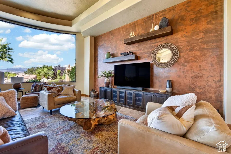 Expansive curved window, textured accent wall, built-in media console, and floating wood shelves