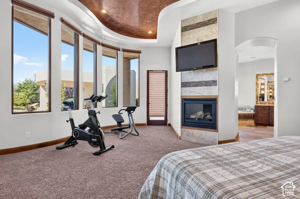 Curved ceiling detail, floor-to-ceiling windows, built-in fireplace with tile surround, arched doorway, and textured wall paneling