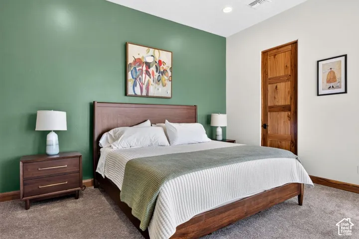 Accent wall, recessed lighting, wood-finish door, wood-finish flooring, and carpeting