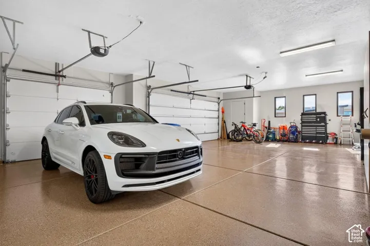 Three-car garage featuring segmented overhead doors and epoxy flooring