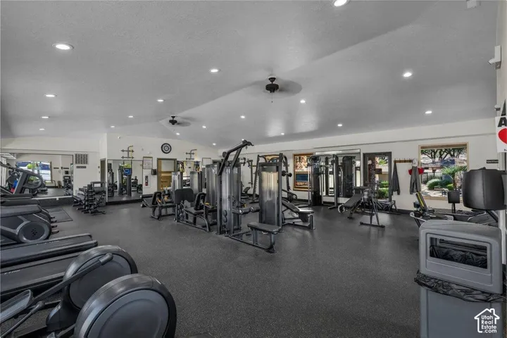 Spacious fitness center featuring recessed lighting, a ceiling fan, mirrored walls, and multiple windows