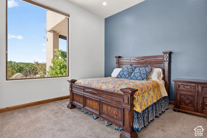 Textured carpeting, a large picture window, and a recessed ceiling light