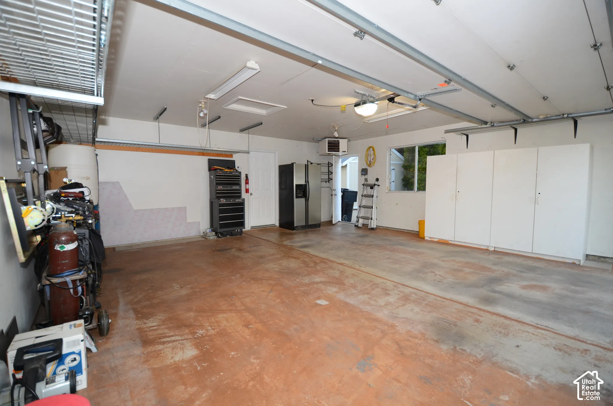 Spacious garage with overhead lighting, built-in cabinetry, shop heater and 220 power for you hobbyists or electric car owners.