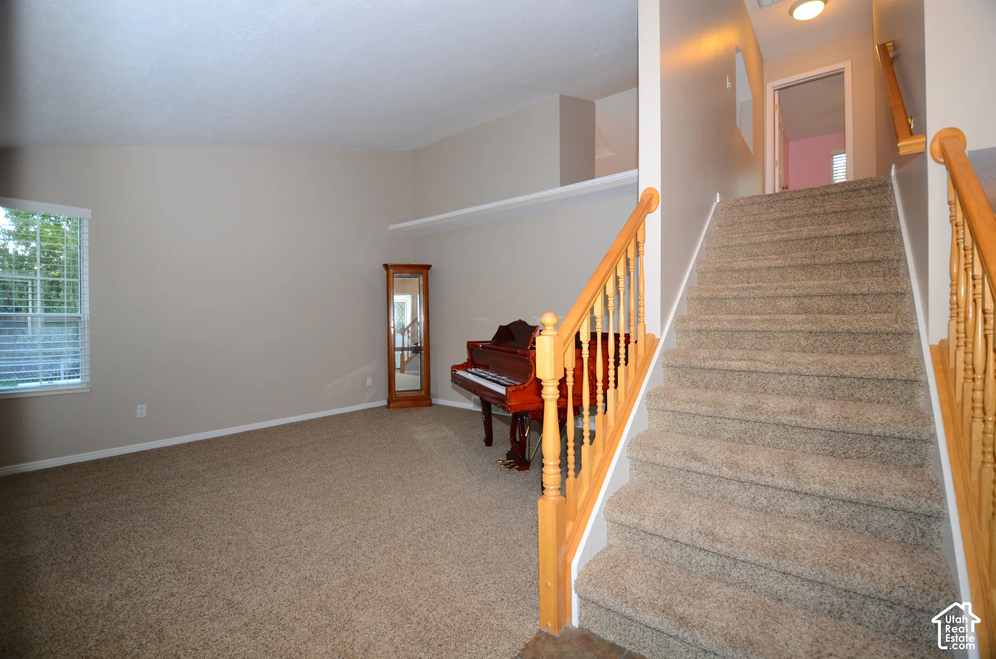 Carpeted living space with a vaulted ceiling and a high-set shelf