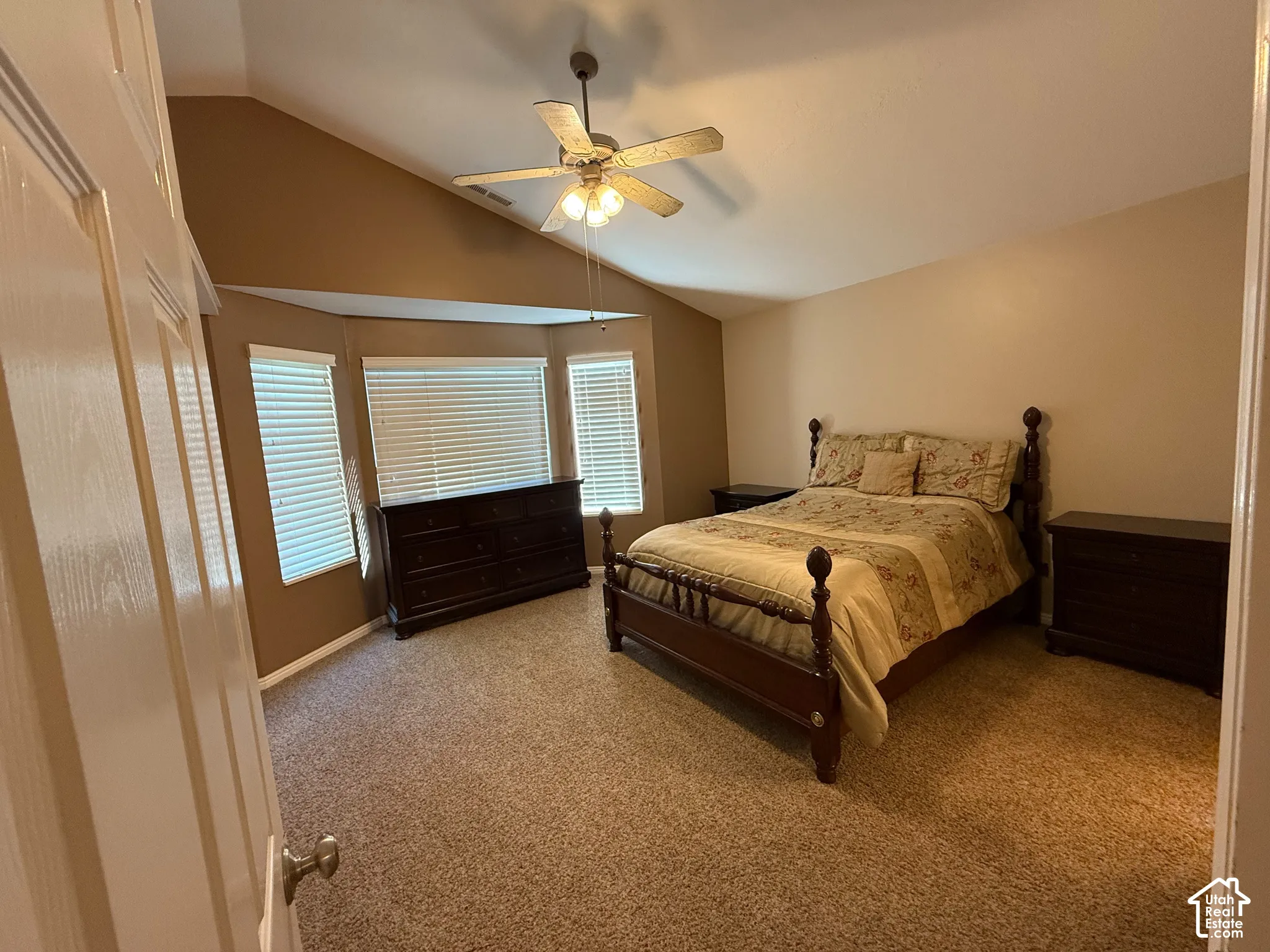 Spaciouis primary bedroom featuring vaulted ceiling, ceiling fan, large bay window, walk in closet and dedicated full bath with large soaker/garden tub.