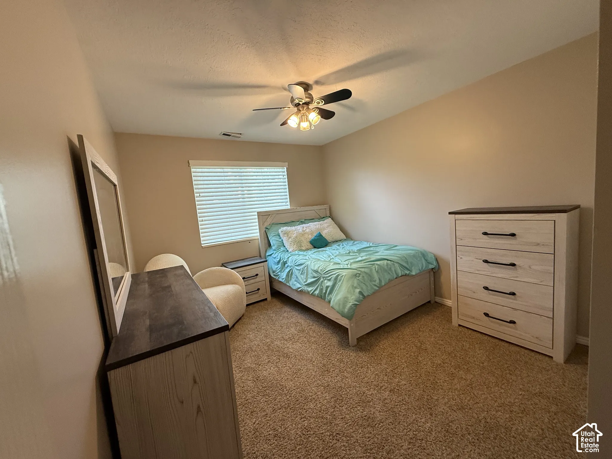 Recessed window with blinds, ceiling fan with light fixture, and carpet flooring