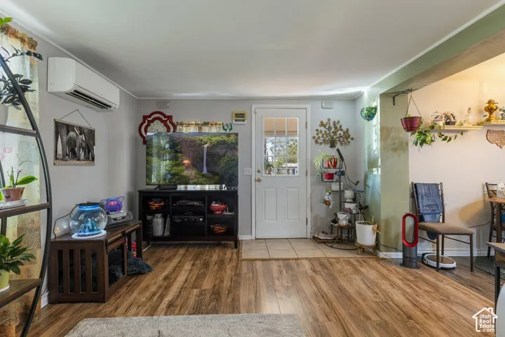 Wood-finish flooring throughout, white interior walls, and a white entry door with glass paneling