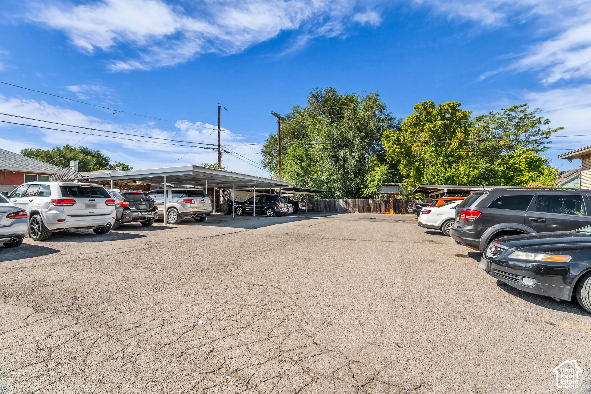 Paved parking area featuring covered carport spaces