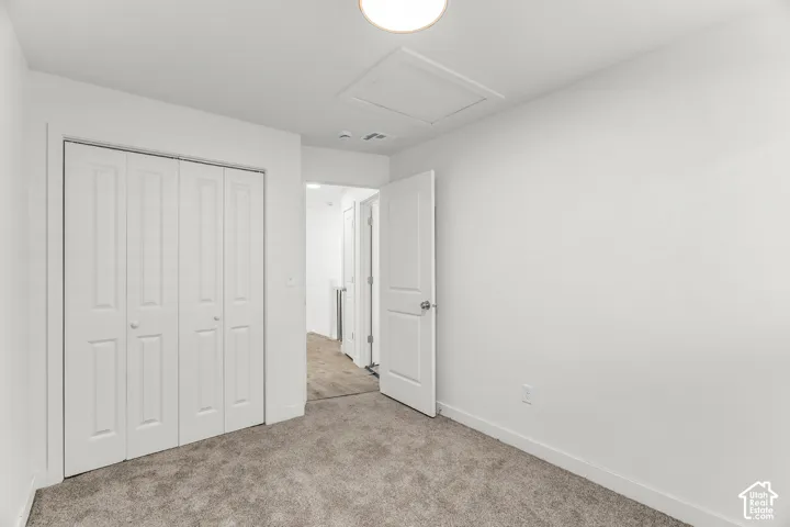 Neutral tone paint, carpeted flooring, white paneled doors, and a flush mount ceiling light