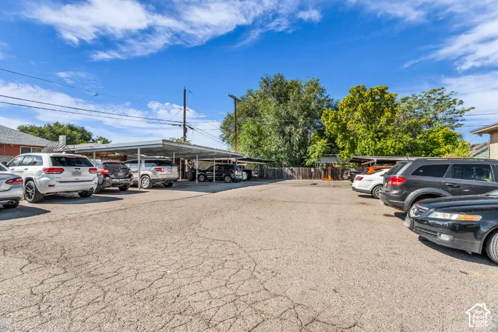 Paved parking area featuring covered carport spaces