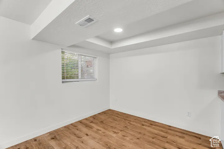Wood-finish flooring, recessed lighting, and a window with blinds