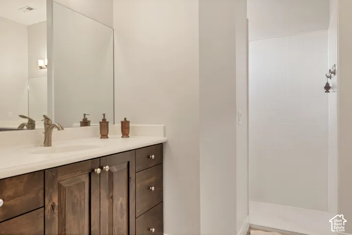 Dark wood-finish vanity with ample storage and white countertop