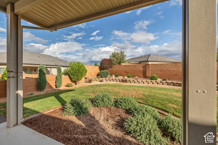 Expansive backyard featuring a manicured lawn, established shrubs, and a tiered landscape design with stone retaining walls