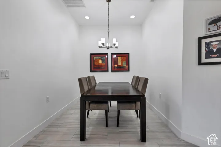 Recessed lighting, central chandelier, and wood-finish flooring