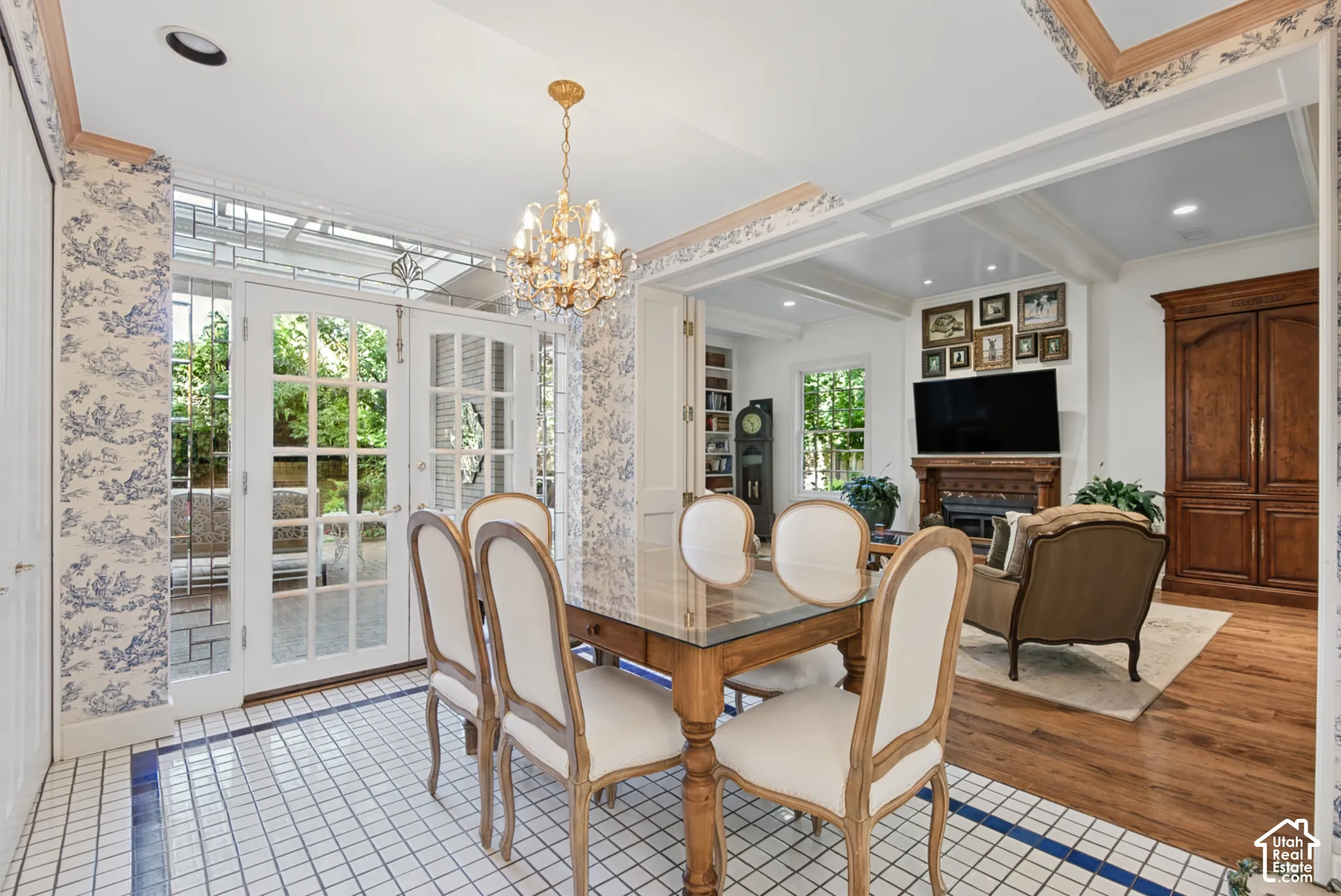 Double French doors, chandelier lighting, coffered ceiling detail, wood-finish flooring, and built-in cabinetry