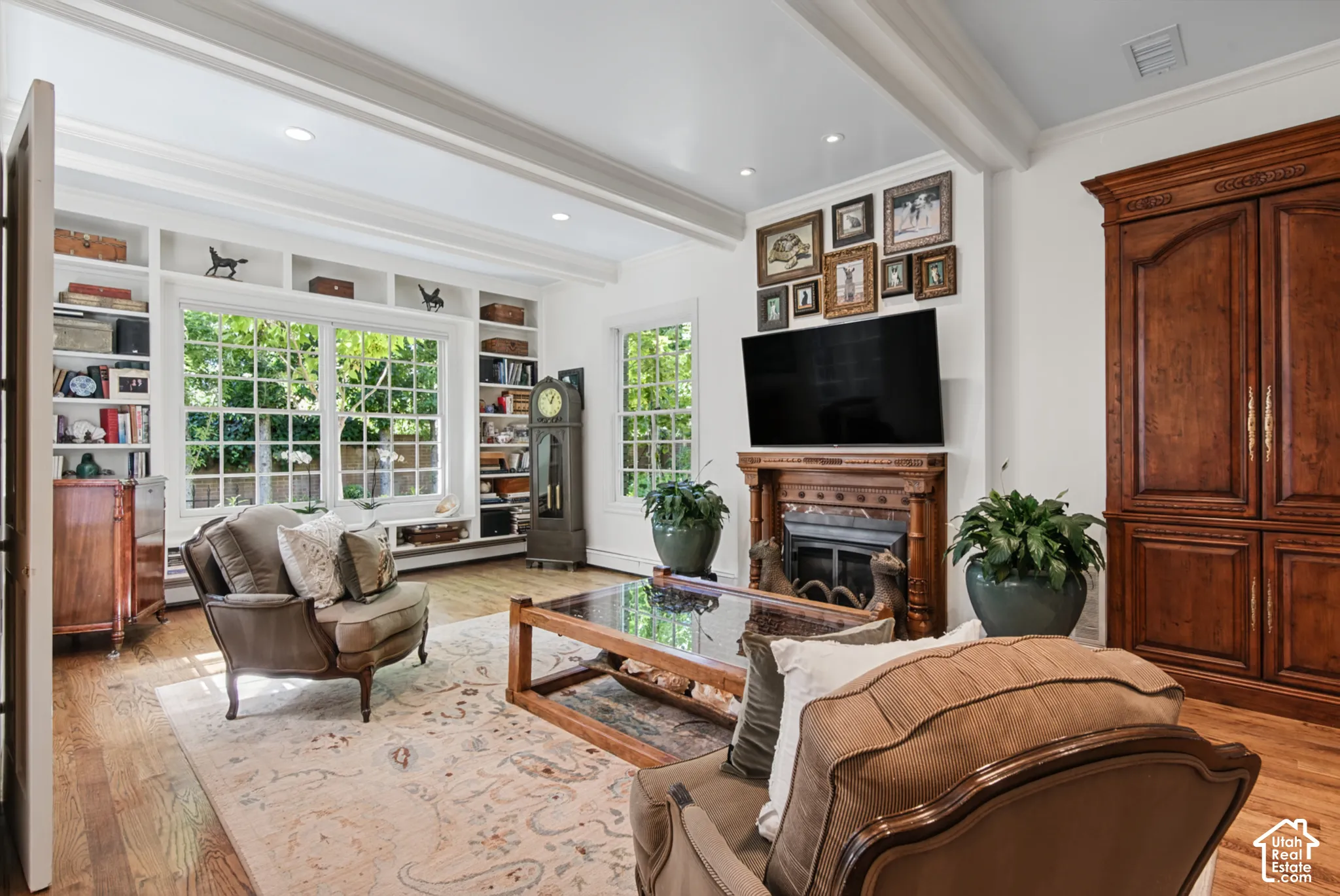 Hardwood flooring, recessed lighting, built-in shelving, wood-mantled fireplace, and built-in wood cabinetry