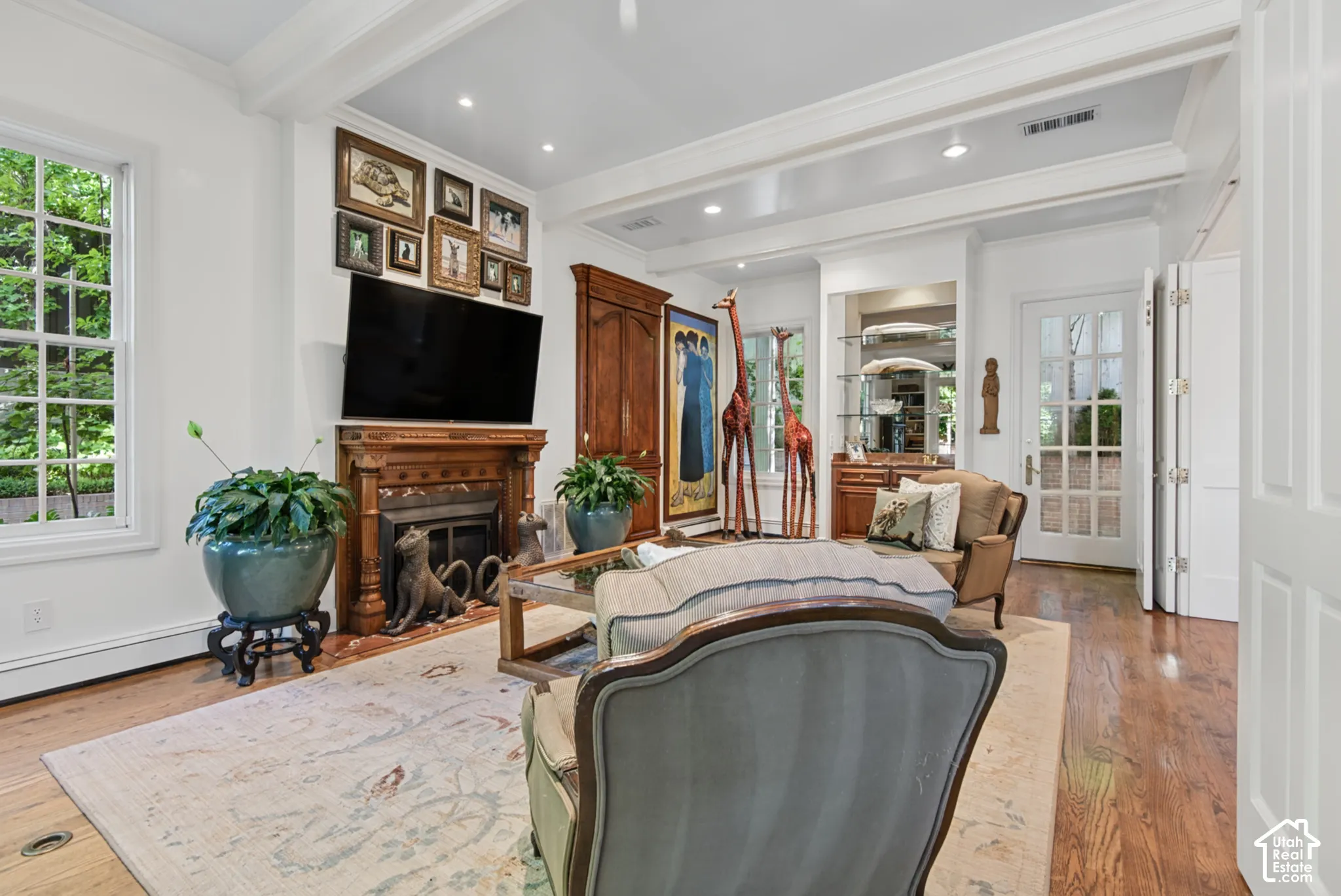 Hardwood flooring, cased windows, decorative fireplace with mantel, recessed lighting, and crown molding