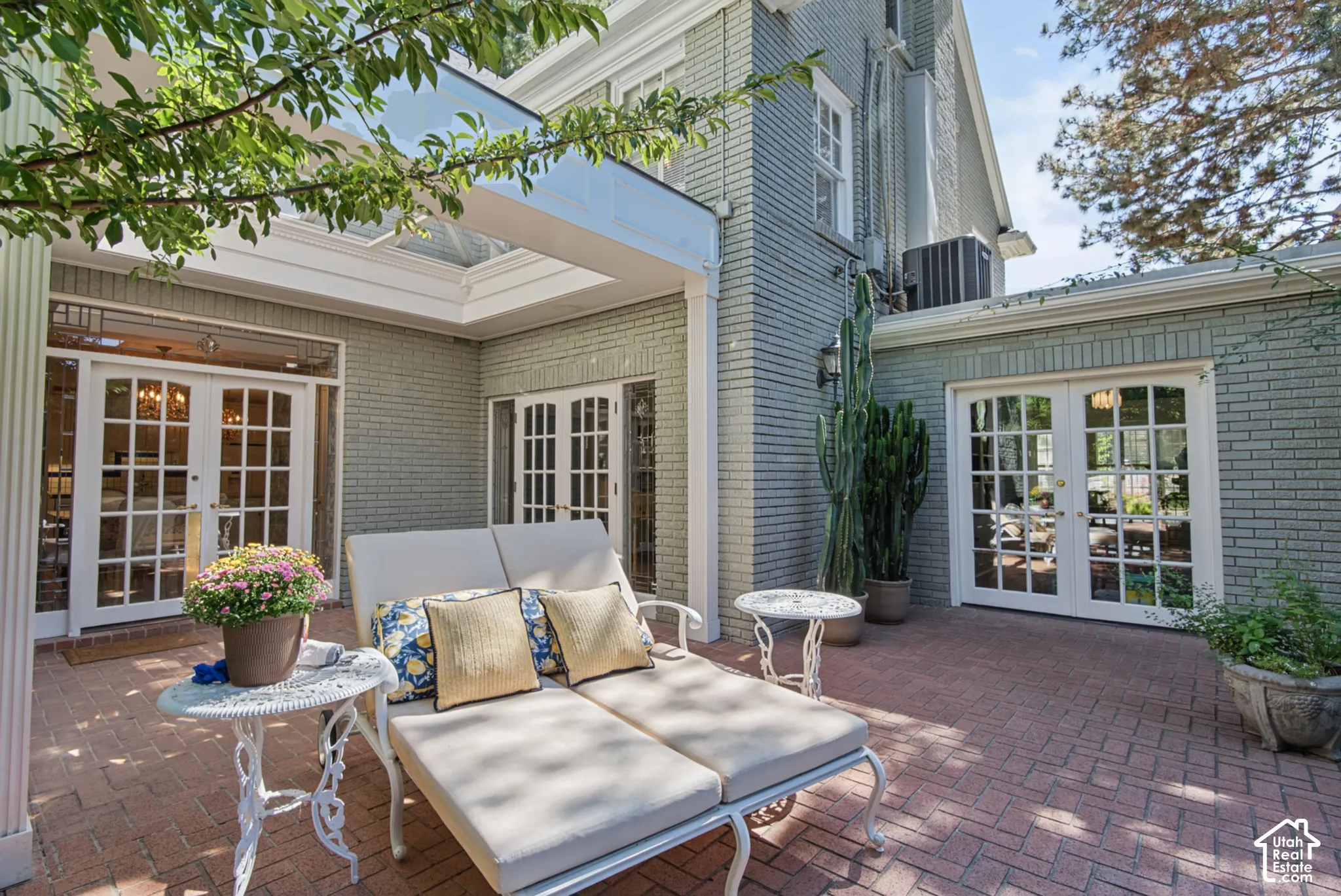 Brick patio featuring a herringbone pattern, multiple sets of glass-paned French doors, and a skylight-covered outdoor area