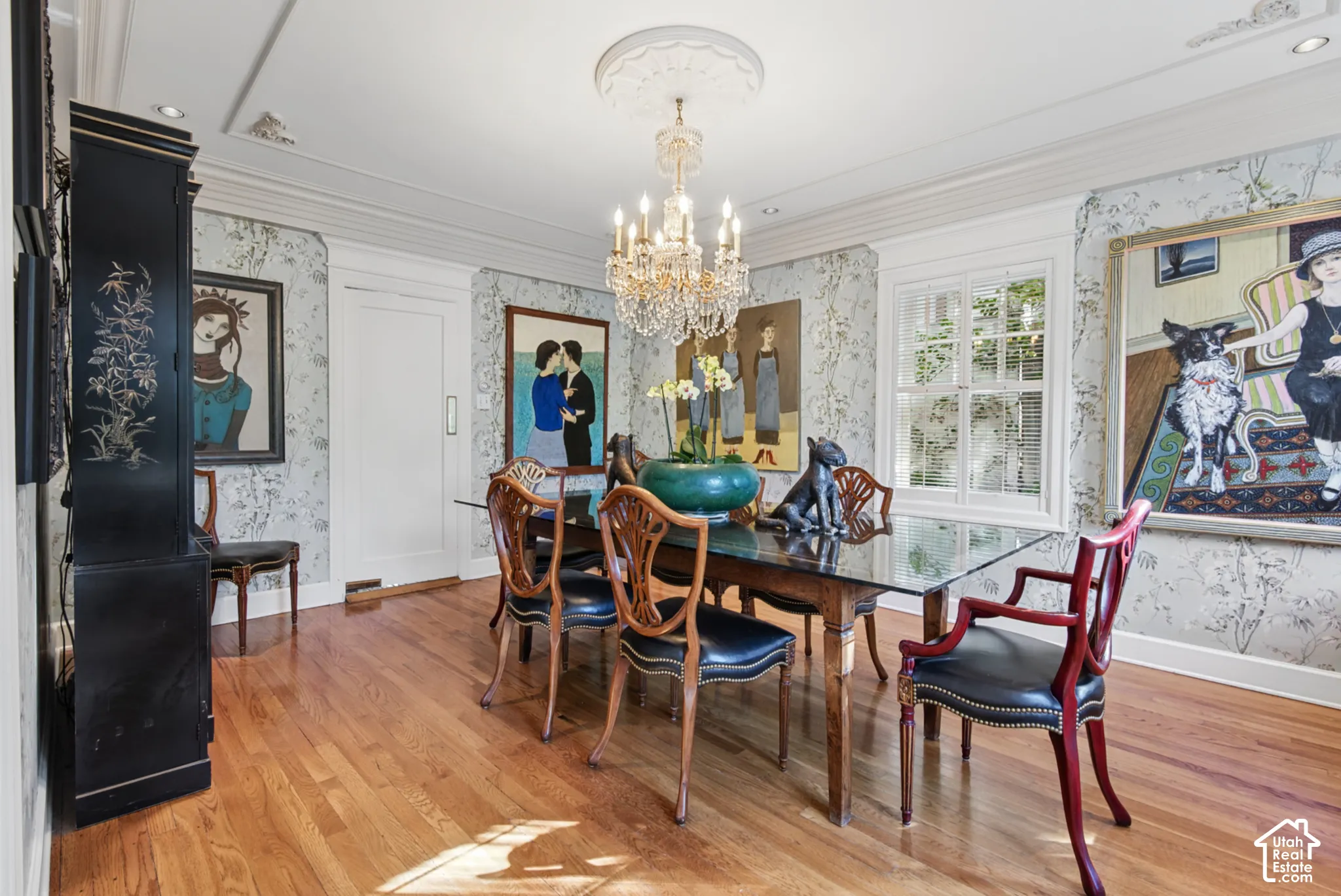 Hardwood flooring, decorative crown molding, and a crystal chandelier