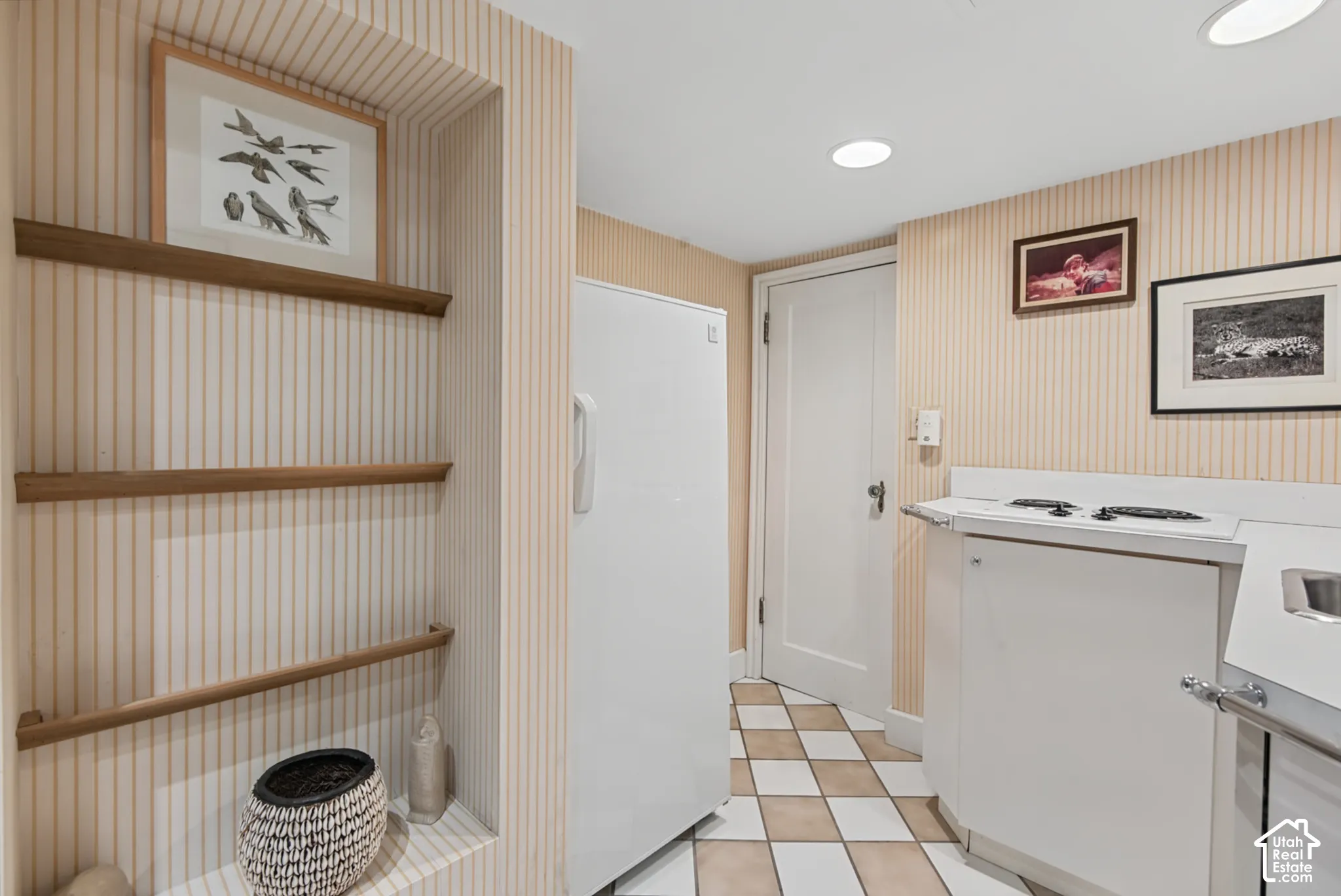 Built-in shelving, recessed lighting, checkerboard floor tiling, and a built-in cooktop